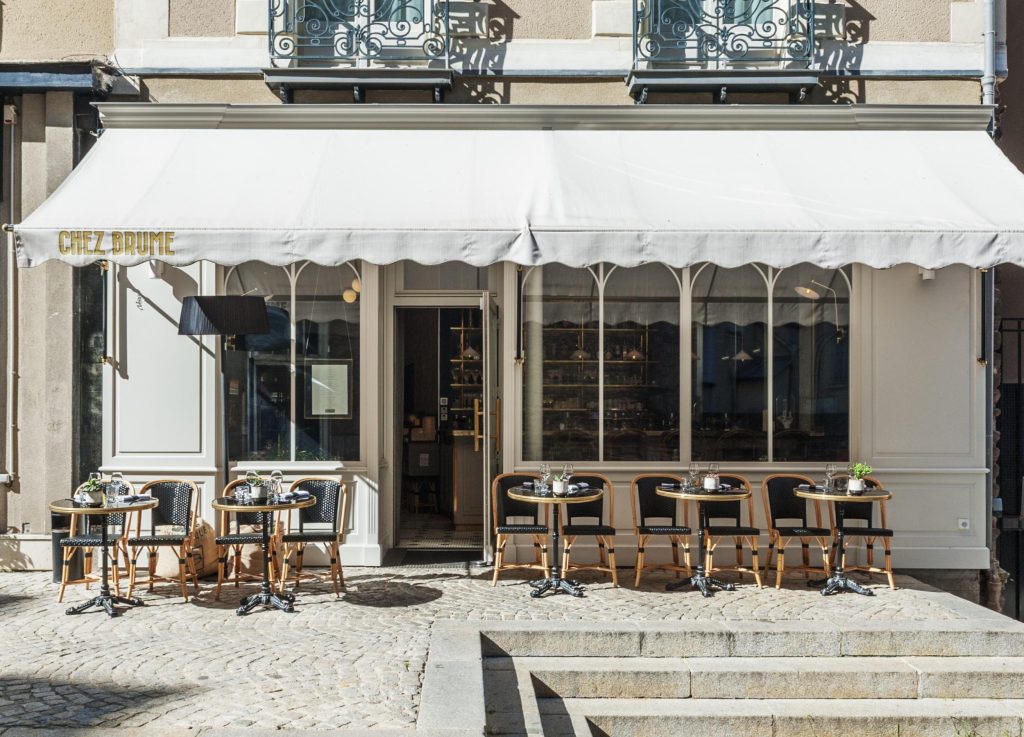 Devanture d'un restaurant avec un store blanc et une terrasse